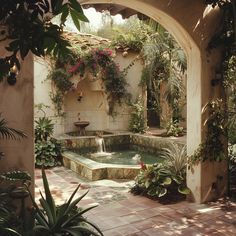 an outdoor fountain surrounded by greenery and potted plants on either side of it