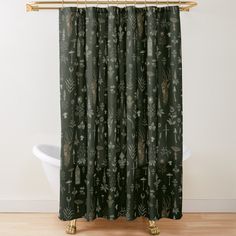 a shower curtain with an animal and plants pattern on it, next to a bathtub