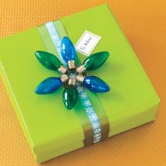 a present wrapped in green paper with a blue flower on it