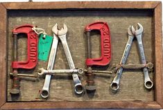 the word dad spelled with wrenches and pliers in a wooden frame on a wall