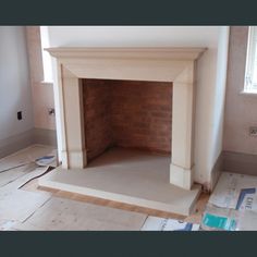 an empty room with a brick fireplace in the middle and several pieces of cardboard on the floor