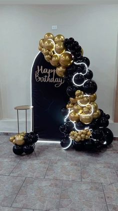 a black and gold balloon arch with balloons on it in the shape of mickey mouses