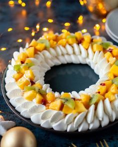 a cake with fruit on it sitting on a table next to other plates and decorations