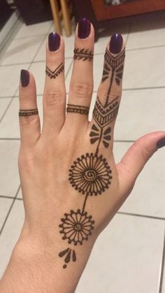 a woman's hand with henna tattoos on it