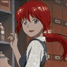 a girl with red hair and blue eyes standing in front of a shelf filled with boxes