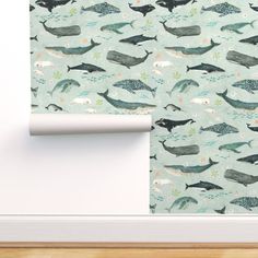 a wallpaper with whales and fish on it, next to a roll of toilet paper