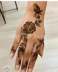 a woman's hand with hennap and flowers painted on it is shown