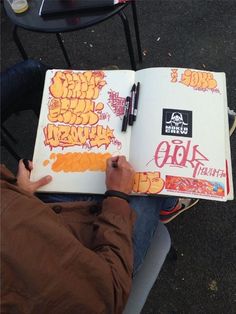 a person sitting down writing on a book