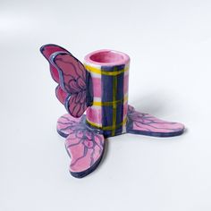 a pink and blue butterfly shaped candle holder