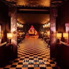 an empty room with black and white checkered flooring, red lights on the ceiling and chandeliers hanging from the ceiling