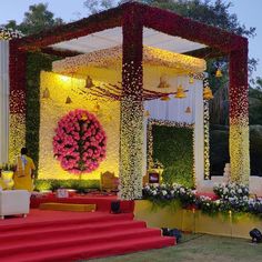 an outdoor wedding setup with flowers and decorations on the stage for guests to sit down