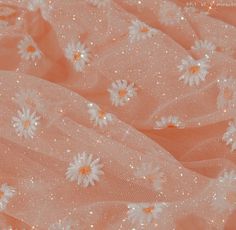 the fabric has daisies on it and is pink with gold glitters around it