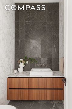 a white toilet sitting next to a bathroom sink under a mirror on top of a wooden cabinet