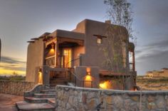 an adobe style home with stone steps leading up to it