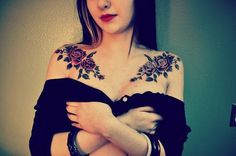 a woman with tattoos on her chest posing for the camera and holding her arms crossed