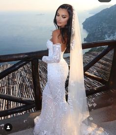 a woman in a wedding dress standing on a balcony