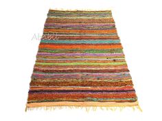 a multicolored rug with fringes on the top and bottom, against a white background