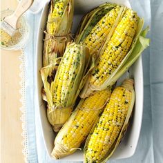 grilled corn on the cob in a white dish