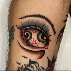 a close up of a person's leg with an eyeball tattoo on it