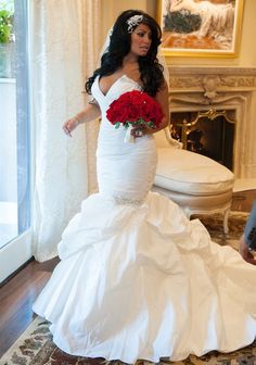 a woman in a white wedding dress with red roses