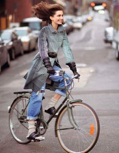 a woman riding a bike down a street