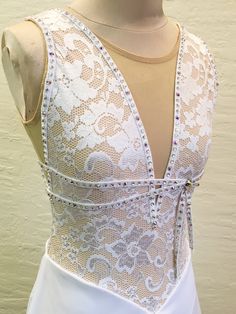 the back of a white dress with beading on it and a mannequin