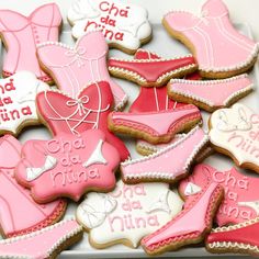 some pink and white decorated cookies in a box