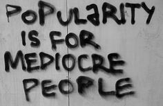 graffiti written on the side of a wall that says, popularity is for mediocre people