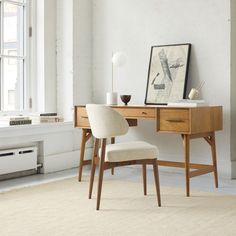 a desk with a chair next to it in front of a window