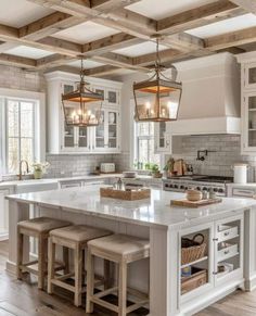 a large kitchen island with stools in the center and two lights hanging from the ceiling