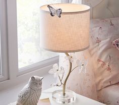 an owl lamp sitting on top of a table next to a window