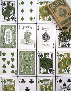 playing cards with green and white designs are arranged on a table next to each other