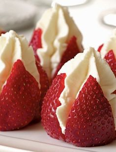 three strawberries with white frosting and red berries