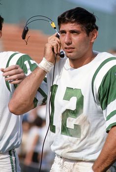 two football players standing next to each other talking on cell phones with wires attached to their ears