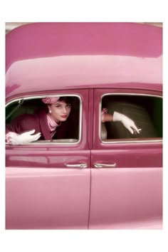 a woman in a pink car with white gloves on