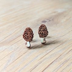 These adorable morel mushroom studs are a great accessory for fungi fans, mushroom hunters, or cottagecore lovers! 🍄. These original earrings feature etched cherry wood with hand-painted details in a realistic palette of natural wood and cream. Lightweight and small, these detailed earrings will add a botanical touch to your wardrobe.  These earrings feature hypoallergenic 304 stainless steel studs with butterfly back closures and are sealed with a semi-gloss varnish on the front for protection and durability. The back is unstained and unsealed cherry wood. Also check out my Morel Mushroom & Fiddlehead Hand-Painted Forager Wood Earrings: https://www.etsy.com/listing/1423732660/morel-mushroom-fiddlehead-hand-painted Interested in creating your own 4-pair stud set? See this listing: https:/ Wood Earrings Stud, Morel Mushroom, Wood Studs, Kraft Gift Boxes, Earring Holder, Stud Set, Hand Painted Wood, Wood Earrings, Wooden Jewelry