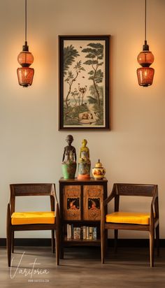 two chairs sitting next to each other in front of a wall with paintings on it