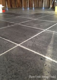 an empty tennis court with white lines painted on the floor and buckets in the background