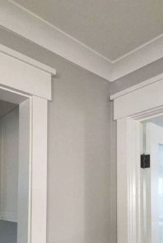 an empty bathroom with white cabinets and gray walls