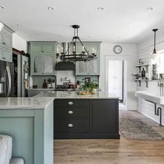 a large kitchen with an island in the middle and lots of cabinets on both sides