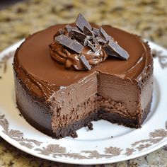 a chocolate cake on a plate with one slice cut out and ready to be eaten