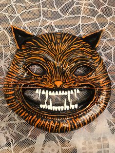 a close up of a cat mask on a table cloth with an animal's face