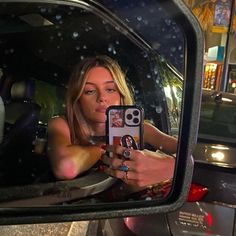 a woman taking a selfie in the back seat of a car with her cell phone