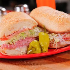 two sub sandwiches are on a red plate