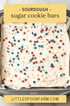 a cake with white frosting and sprinkles on it in a pan