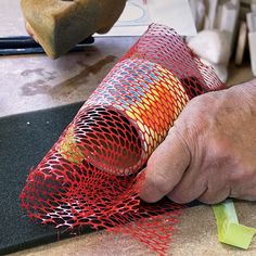 a man is working on something with red mesh