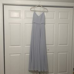 a dress hanging on a hanger in front of a door