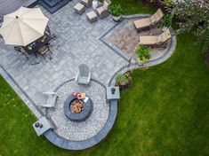 an aerial view of a patio and fire pit in the middle of a lawn area