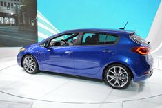 a blue car is on display at an auto show