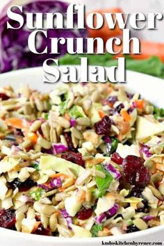 a white bowl filled with salad next to lettuce and cranberries